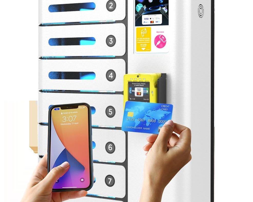 A hand holding a payment card and a phone at the numbered bays of a charging locker