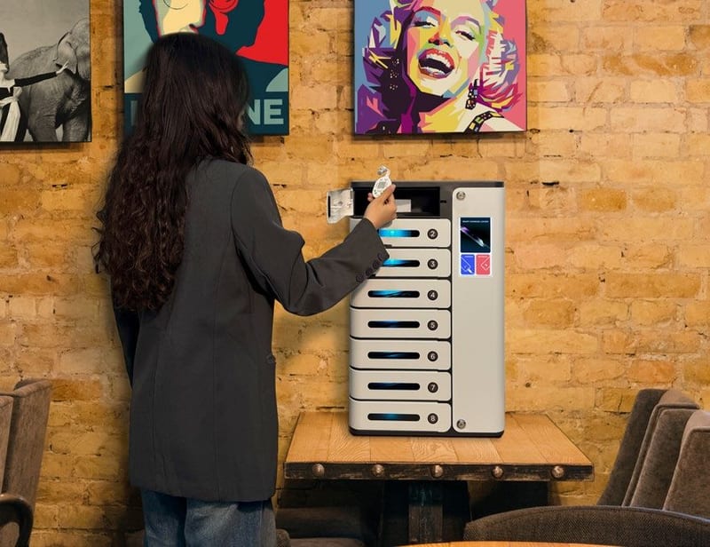 A person setting a code at a wall-mounted charging locker in a bar