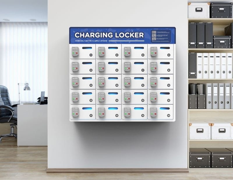 A wide wall-mounted charging locker with rows of small numbered bays, fitted in an office